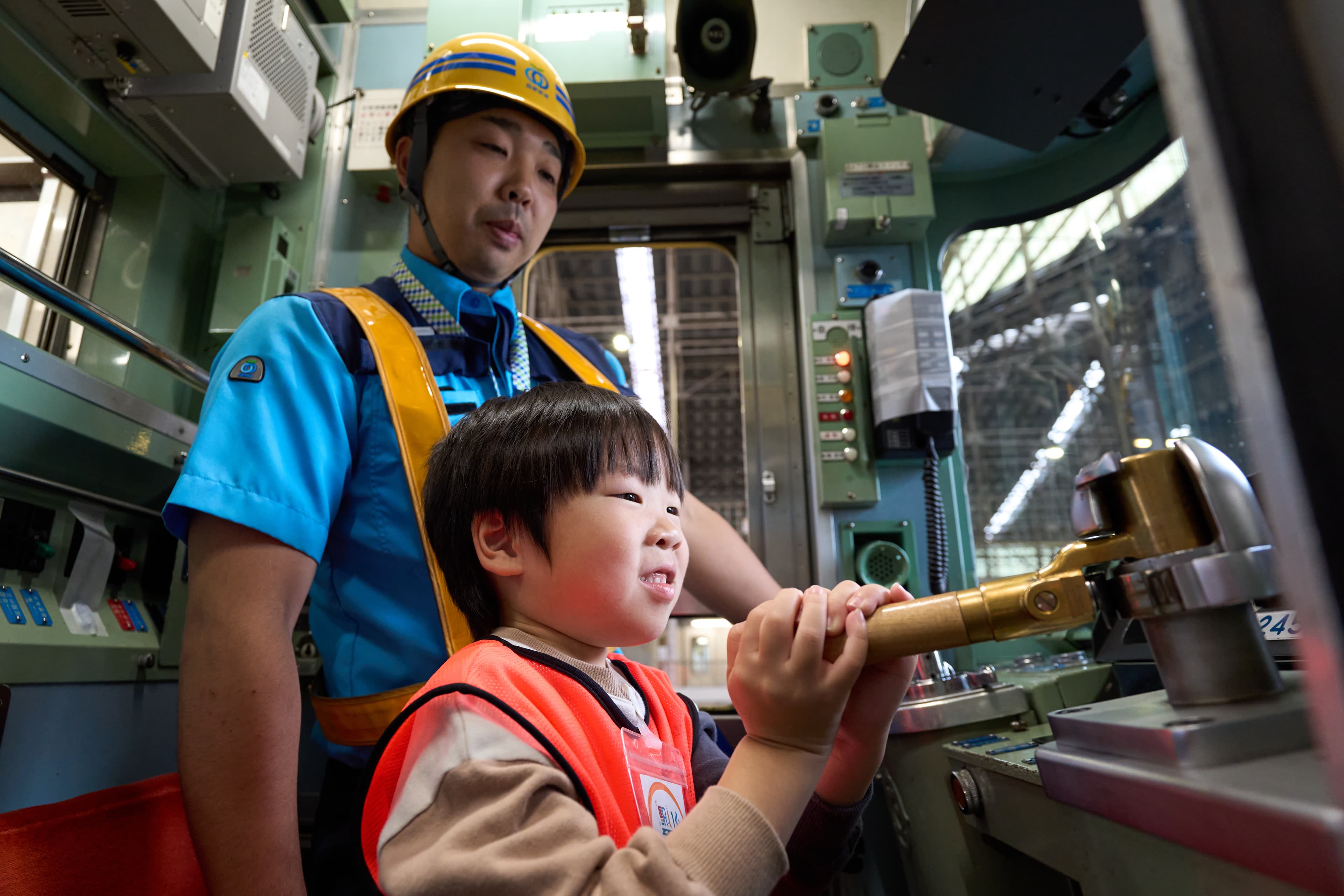 鉄道会社のスタッフが子どもに業務を教えている場面